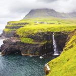 Dramatic waterfall on Faroe Islands and the village Gasadalur