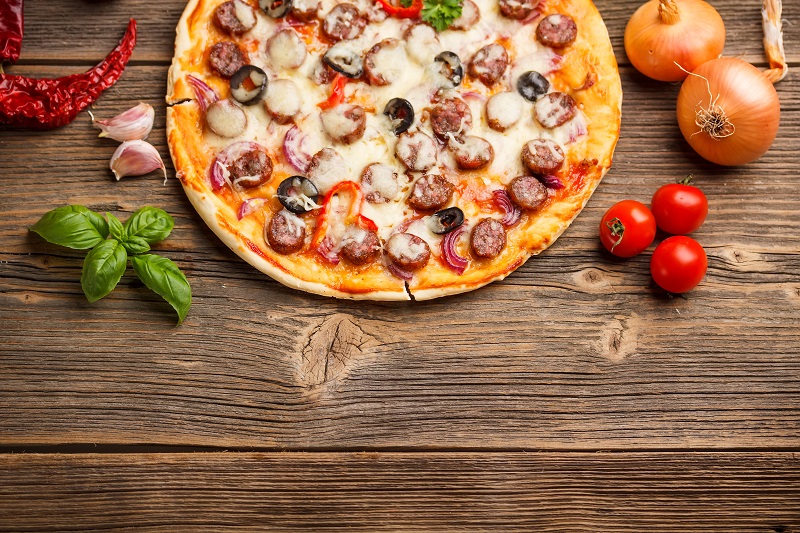 Pizza served on rustic wooden table