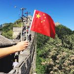hand-holding-flag-of-china-in-the-great-wall-of-china