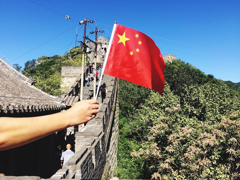 hand-holding-flag-of-china-in-the-great-wall-of-china