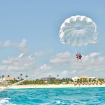 couple-parasailing-over-crystal-blue-water-in-domi
