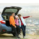 Family standing near car and enjoying nature.