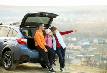 Family standing near car and enjoying nature.