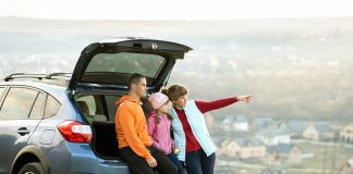 Family standing near car and enjoying nature.