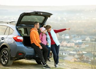 Family standing near car and enjoying nature.