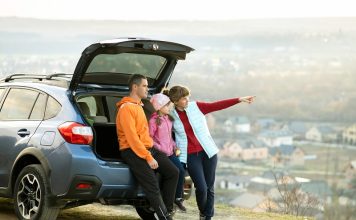 Family standing near car and enjoying nature.