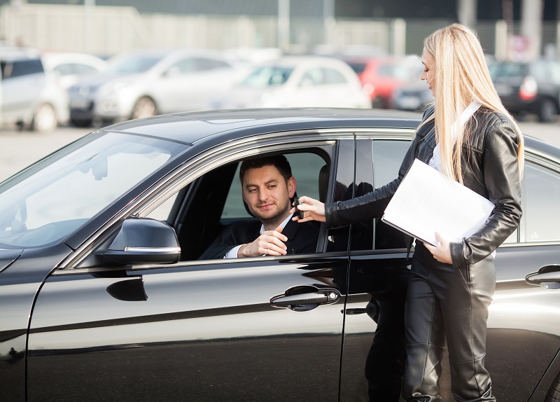 Happy couple buy new modern black car